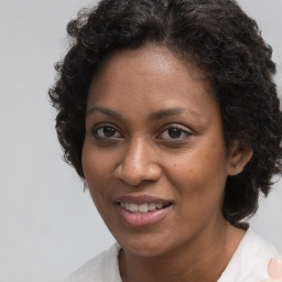 Joyful black adult female with medium  brown hair and brown eyes