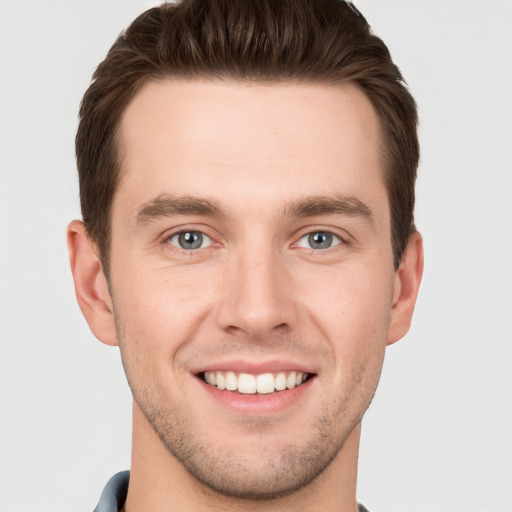 Joyful white young-adult male with short  brown hair and grey eyes