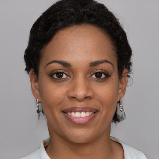 Joyful black young-adult female with medium  black hair and brown eyes