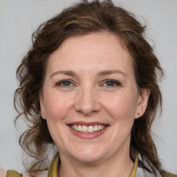 Joyful white adult female with medium  brown hair and blue eyes