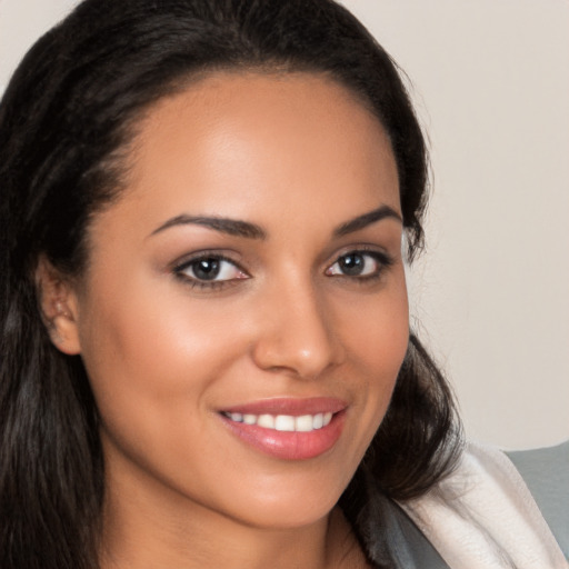 Joyful latino young-adult female with long  brown hair and brown eyes