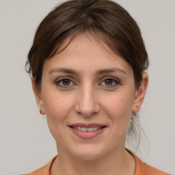 Joyful white young-adult female with medium  brown hair and grey eyes