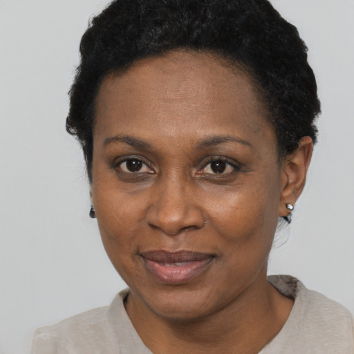 Joyful black adult female with short  black hair and brown eyes