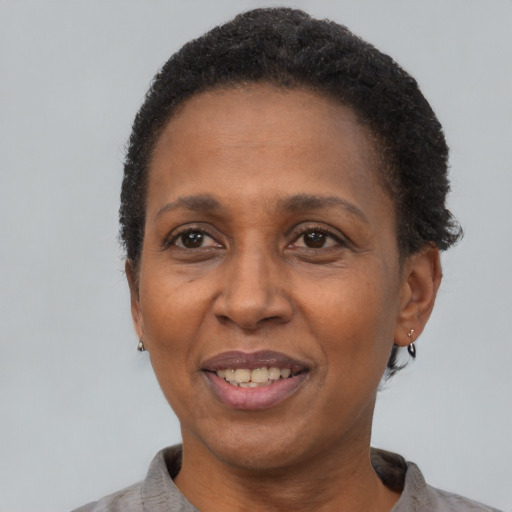 Joyful black adult female with short  black hair and brown eyes