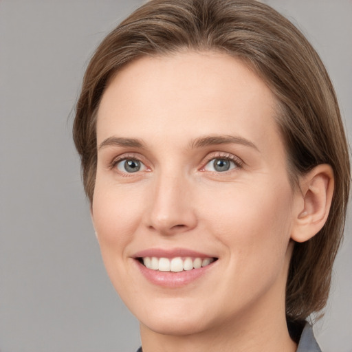 Joyful white young-adult female with medium  brown hair and grey eyes