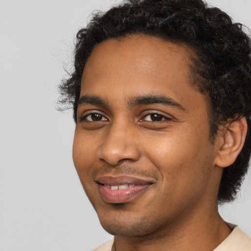 Joyful black young-adult male with short  black hair and brown eyes