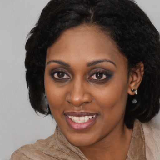 Joyful black young-adult female with medium  black hair and brown eyes