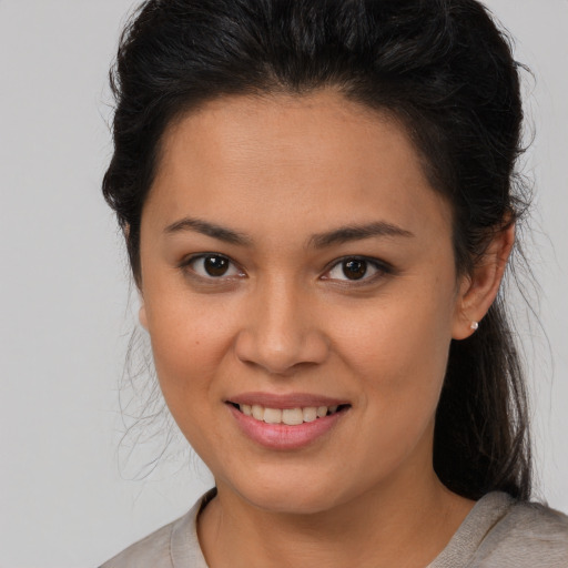 Joyful latino young-adult female with medium  brown hair and brown eyes