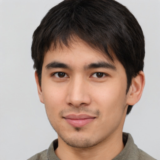 Joyful asian young-adult male with short  brown hair and brown eyes