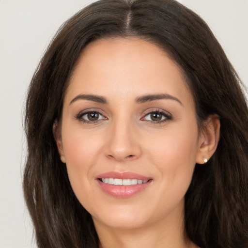 Joyful white young-adult female with long  brown hair and brown eyes