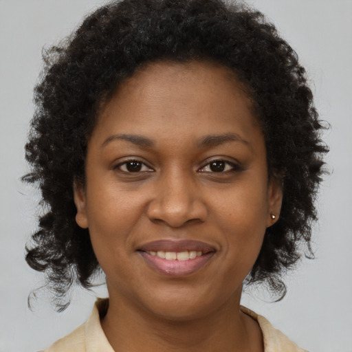 Joyful black young-adult female with short  brown hair and brown eyes