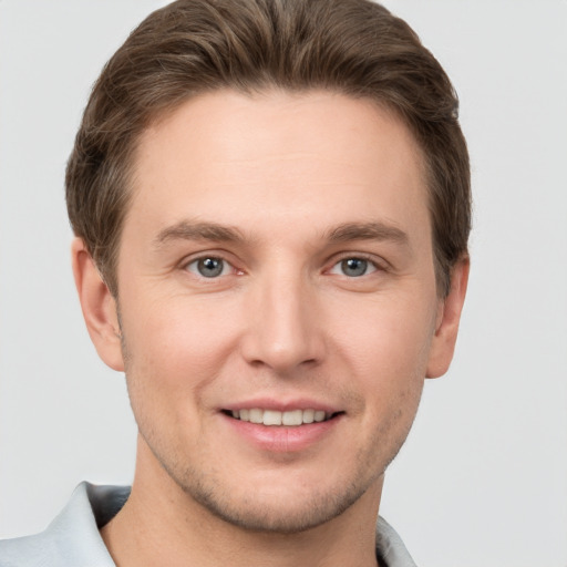 Joyful white young-adult male with short  brown hair and grey eyes