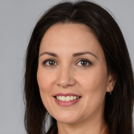 Joyful white adult female with long  brown hair and brown eyes