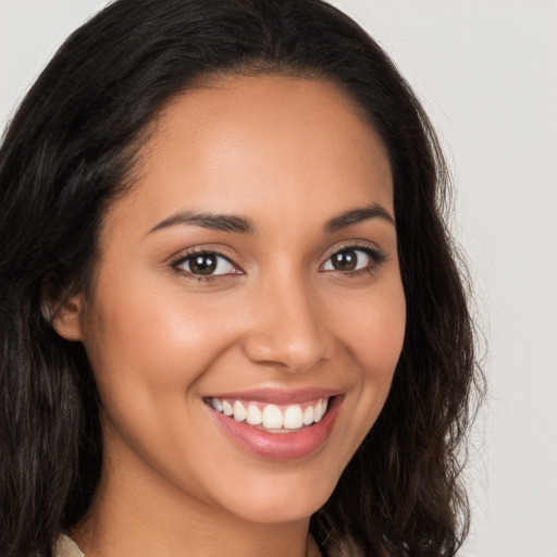 Joyful latino young-adult female with long  brown hair and brown eyes