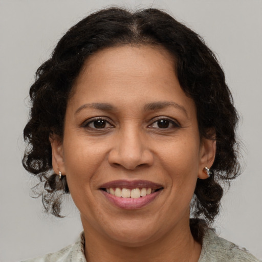 Joyful latino adult female with medium  brown hair and brown eyes