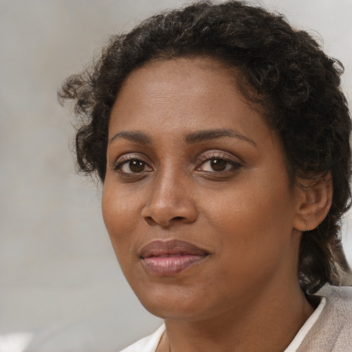 Joyful black adult female with short  brown hair and brown eyes