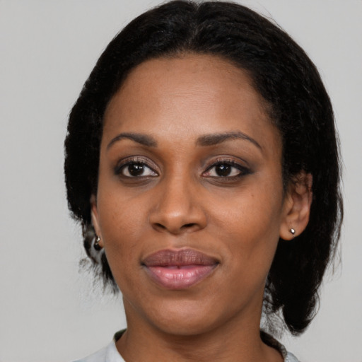 Joyful latino adult female with medium  black hair and brown eyes