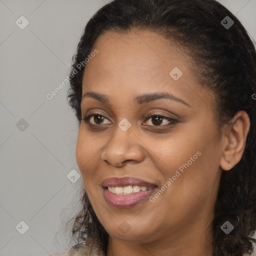 Joyful black young-adult female with long  brown hair and brown eyes