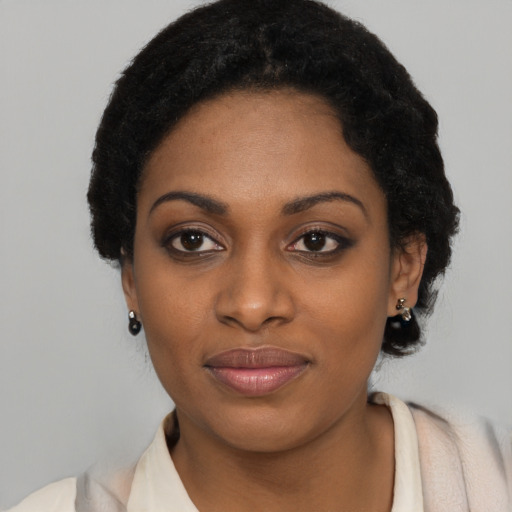 Joyful black young-adult female with short  black hair and brown eyes