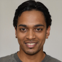 Joyful black young-adult male with short  black hair and brown eyes