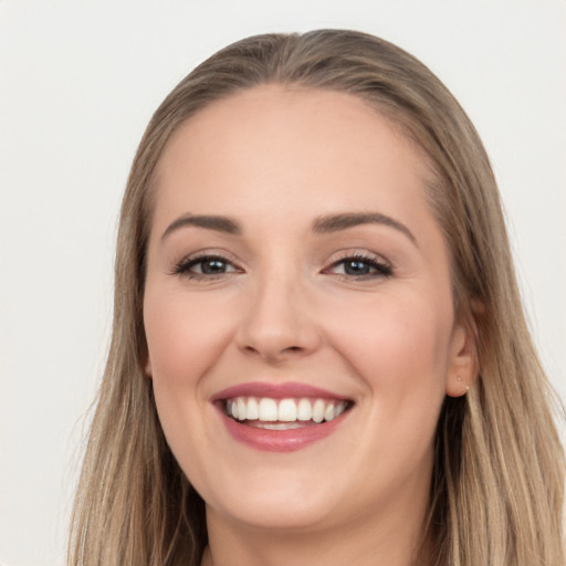 Joyful white young-adult female with long  brown hair and brown eyes