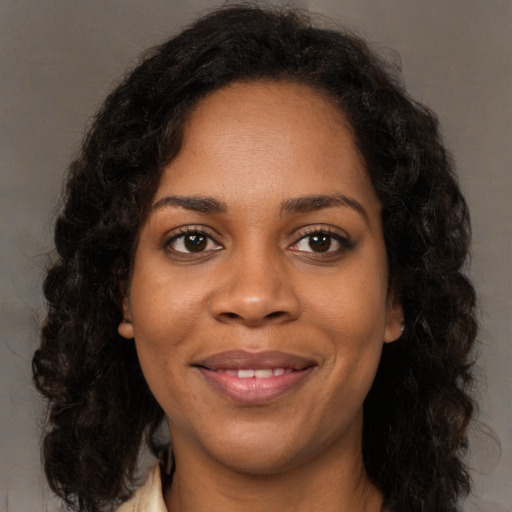 Joyful black young-adult female with long  black hair and brown eyes