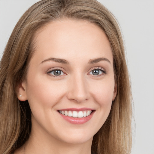 Joyful white young-adult female with long  brown hair and blue eyes