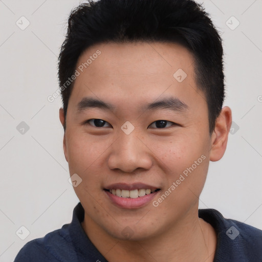 Joyful asian young-adult male with short  black hair and brown eyes