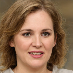 Joyful white young-adult female with medium  brown hair and green eyes