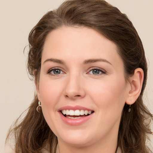 Joyful white young-adult female with long  brown hair and grey eyes