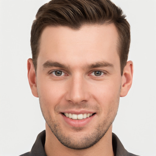 Joyful white young-adult male with short  brown hair and grey eyes