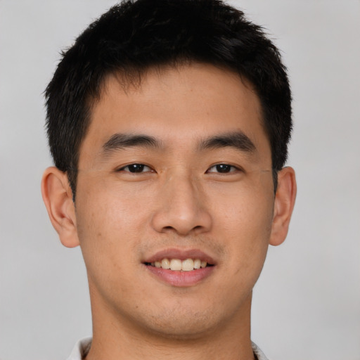 Joyful asian young-adult male with short  brown hair and brown eyes