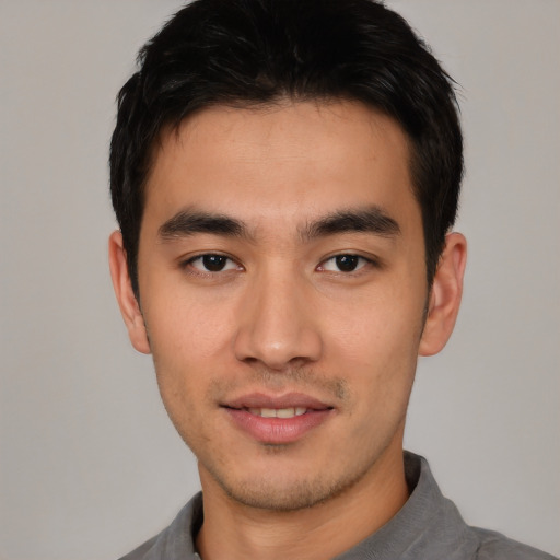 Joyful asian young-adult male with short  black hair and brown eyes