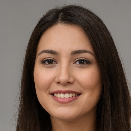 Joyful white young-adult female with long  brown hair and brown eyes