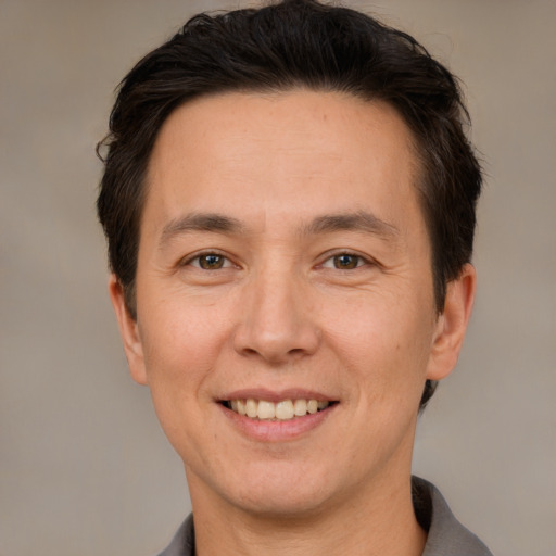 Joyful white adult male with short  brown hair and brown eyes