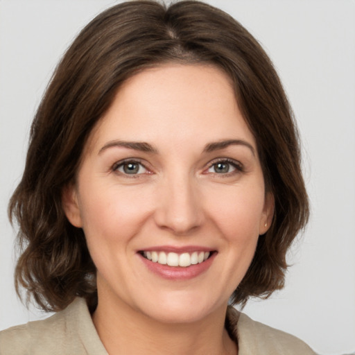 Joyful white young-adult female with medium  brown hair and green eyes