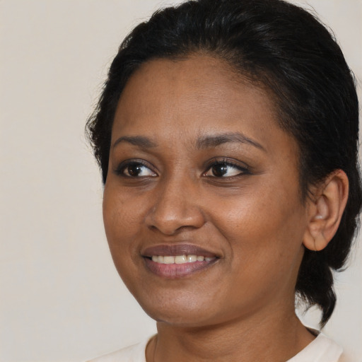 Joyful black young-adult female with medium  brown hair and brown eyes