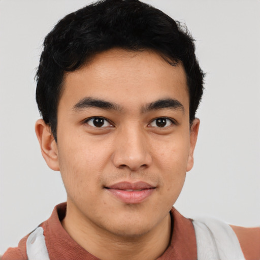 Joyful latino young-adult male with short  brown hair and brown eyes