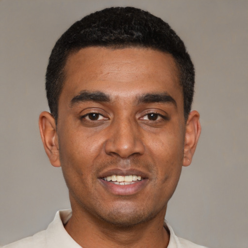 Joyful black young-adult male with short  black hair and brown eyes
