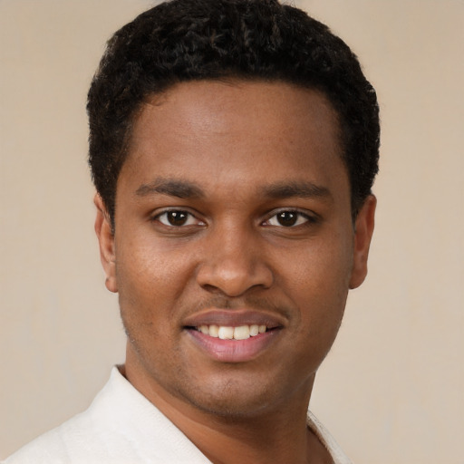 Joyful black young-adult male with short  black hair and brown eyes