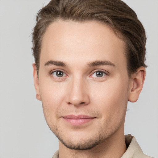 Joyful white young-adult male with short  brown hair and grey eyes