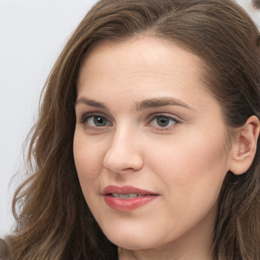 Joyful white young-adult female with long  brown hair and grey eyes