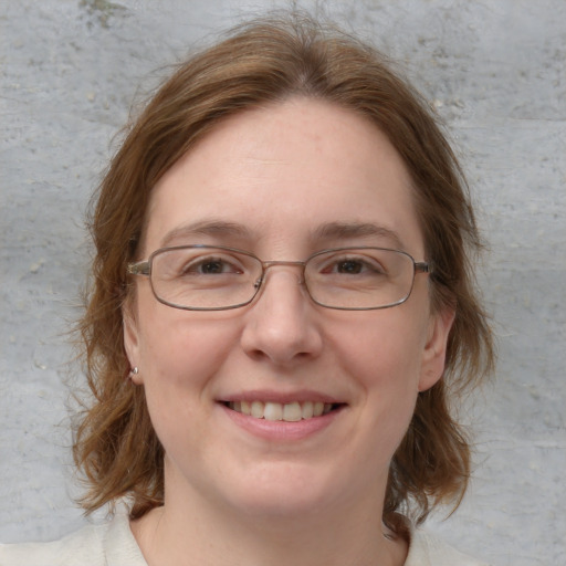 Joyful white adult female with medium  brown hair and blue eyes