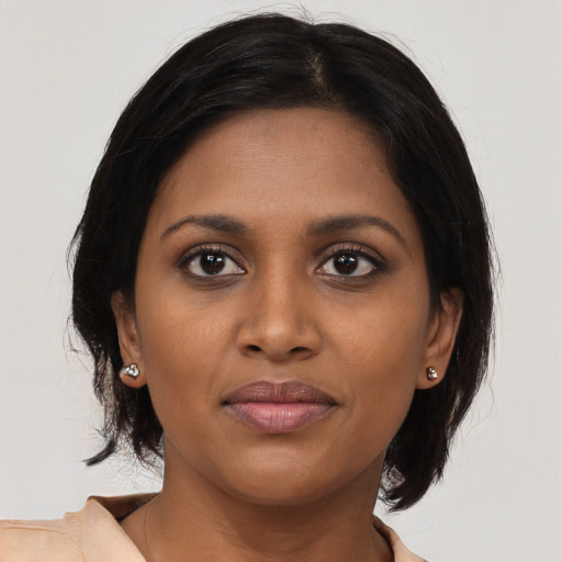 Joyful black young-adult female with medium  brown hair and brown eyes
