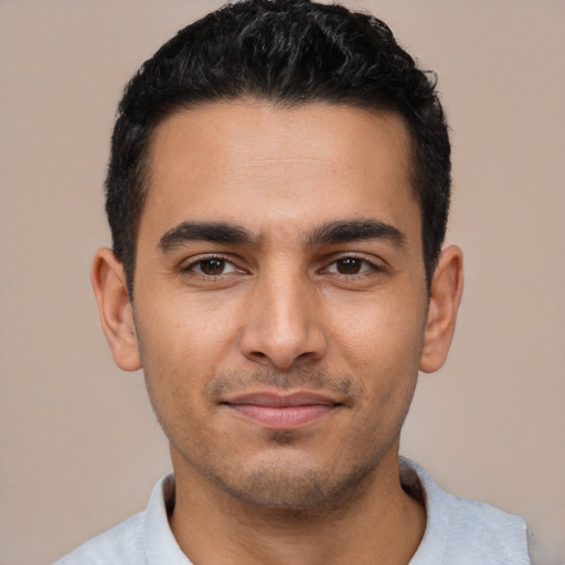 Joyful latino young-adult male with short  black hair and brown eyes