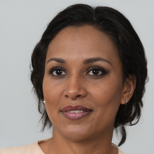 Joyful black adult female with medium  brown hair and brown eyes