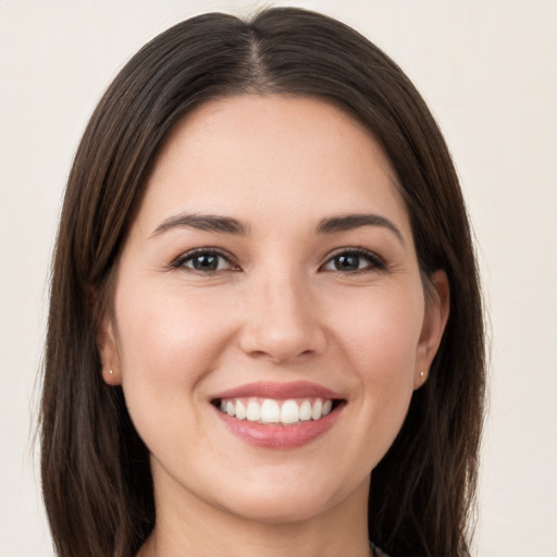 Joyful white young-adult female with long  brown hair and brown eyes