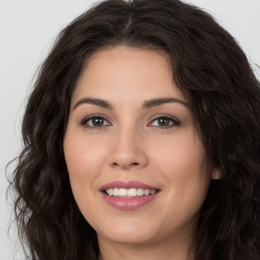 Joyful white young-adult female with long  brown hair and brown eyes