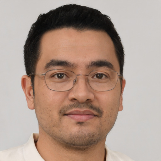 Joyful latino adult male with short  black hair and brown eyes