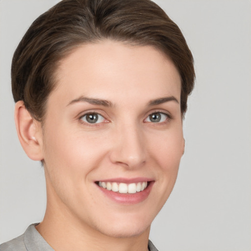 Joyful white young-adult female with short  brown hair and grey eyes